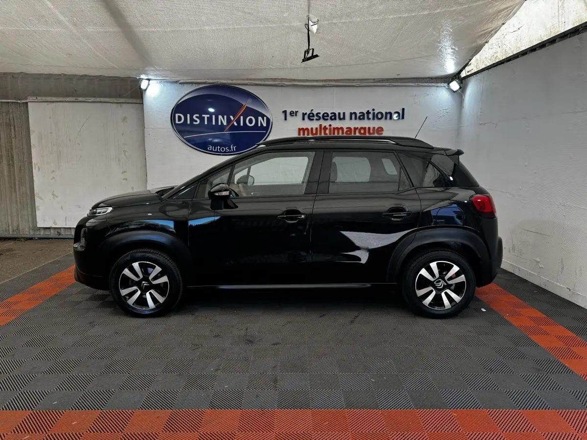 Profil latéral droit d'un Citroën C3 Aircross noir 2020, avec jantes alliage et barres de toit noires visibles en intérieur.