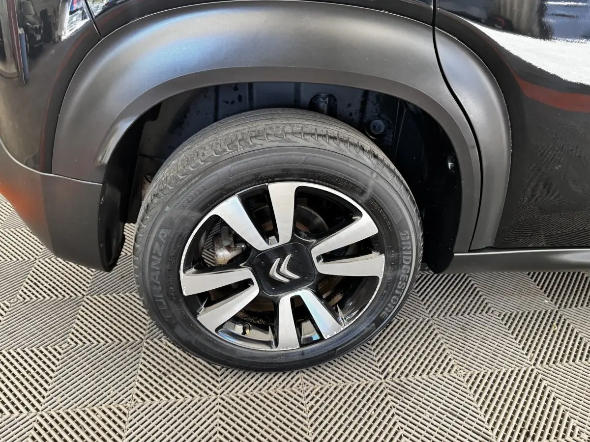Gros plan sur la roue avant gauche noire avec jante alliage bicolore du Citroën C3 Aircross 2020.