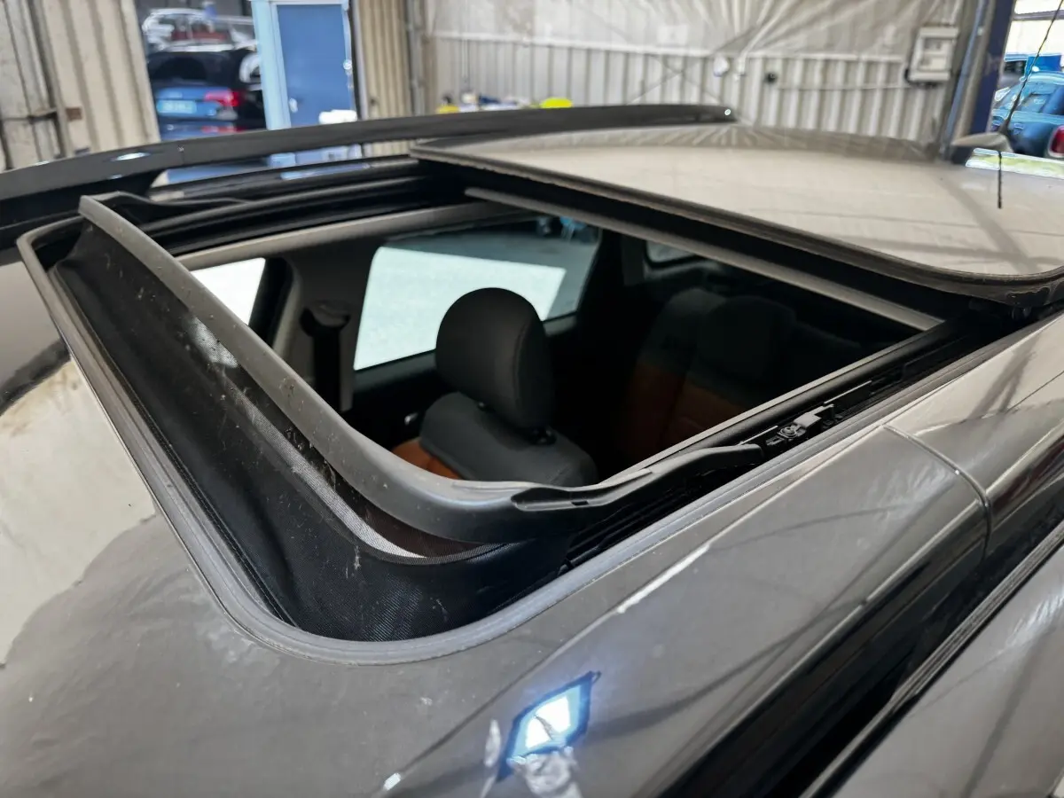 Toit ouvrant panoramique ouvert sur le côté gauche d'une Citroën C3 Aircross noire, intérieur partiellement visible.
