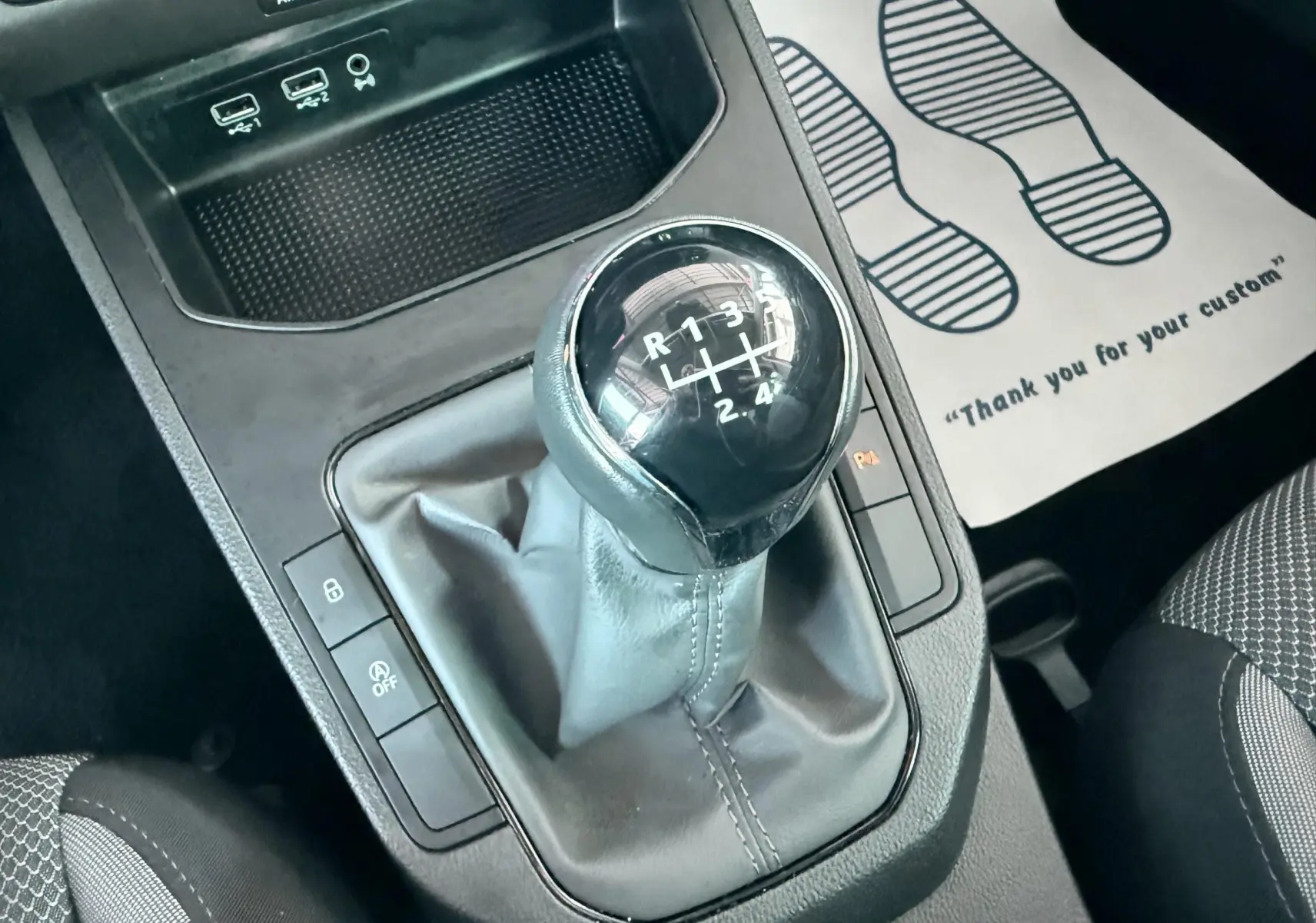 Gros plan sur le levier de vitesses manuel noir de la SEAT Ibiza 2020, avec console centrale et port USB visibles.