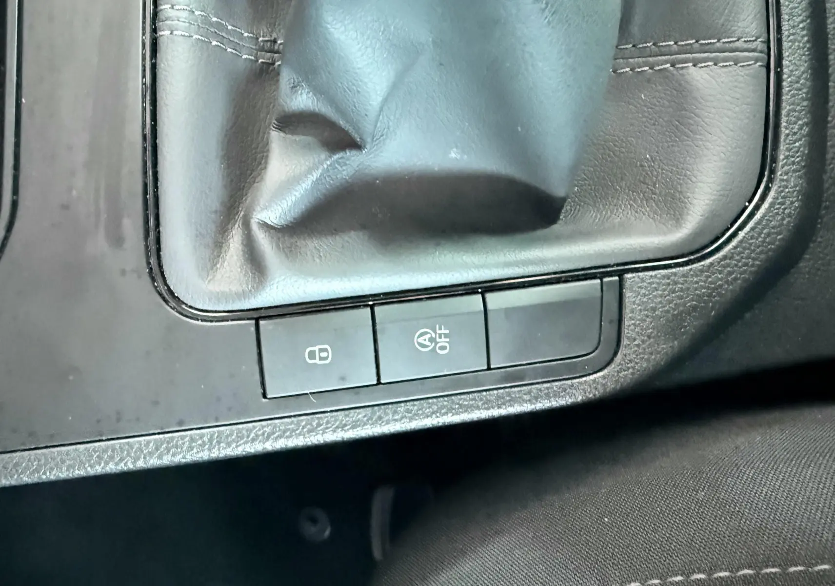 Gros plan sur le levier de vitesses et les boutons de commande du système start-stop dans l'habitacle noir d'une SEAT Ibiza.