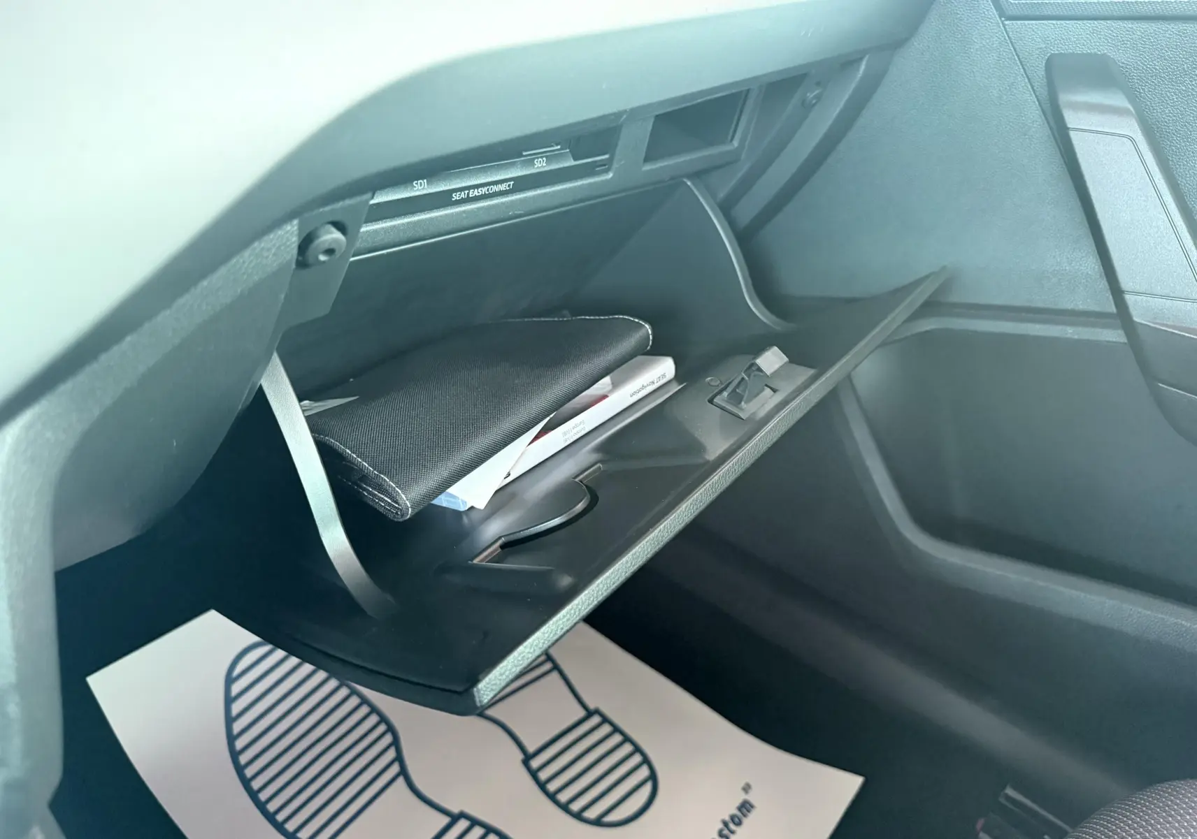 Intérieur de la boîte à gants ouverte d'une SEAT Ibiza 2020, version Urban, avec documents visibles.