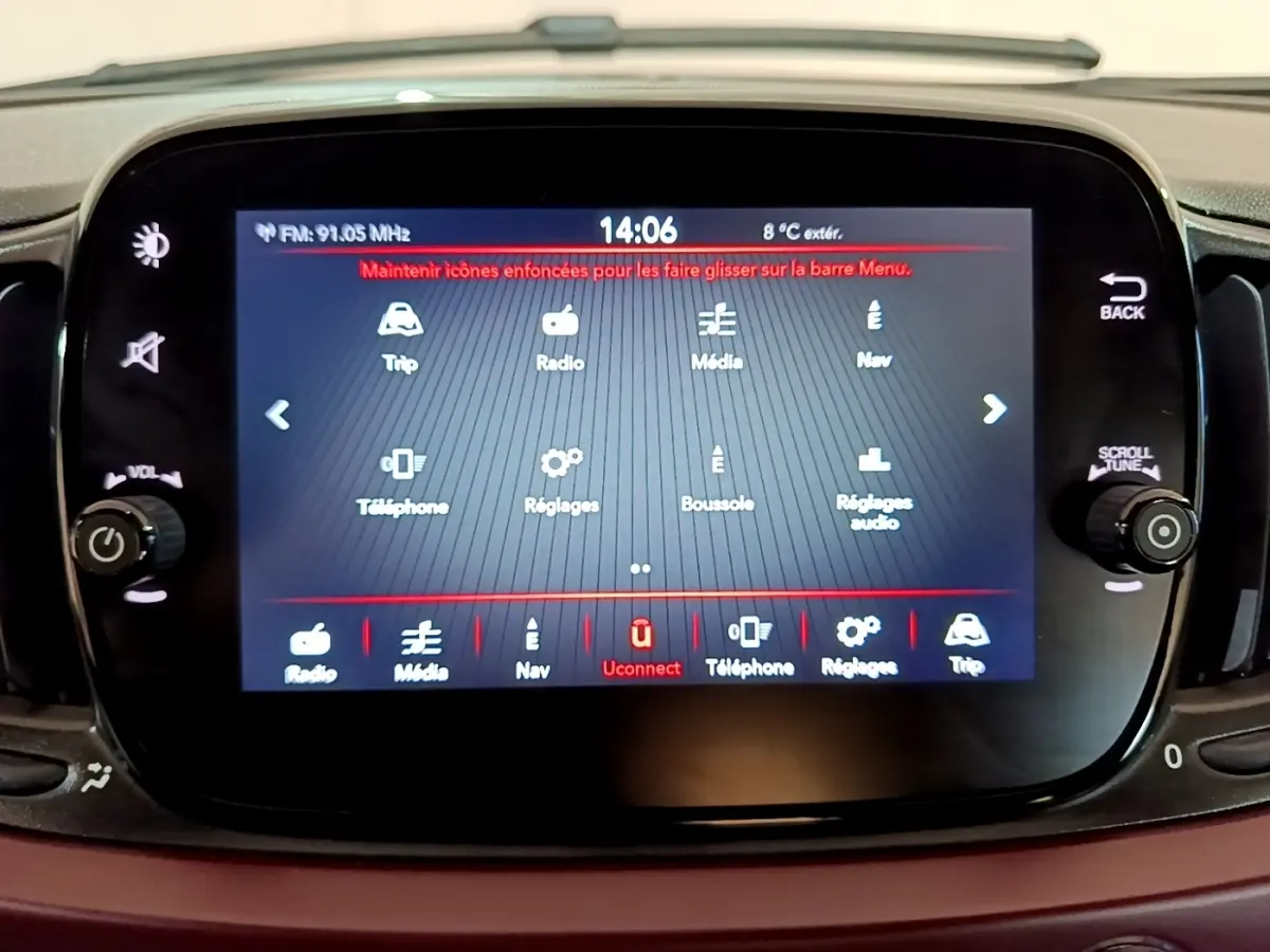 Écran tactile central du tableau de bord de la Fiat 500 rouge, affichant le menu multimédia et réglages.
