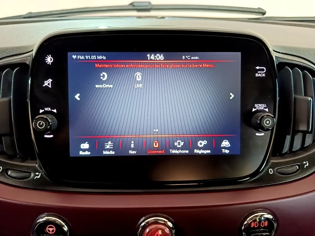 Écran tactile central allumé sur tableau de bord rouge de la Fiat 500 1.0 70ch BSG Star, vue intérieure frontale.