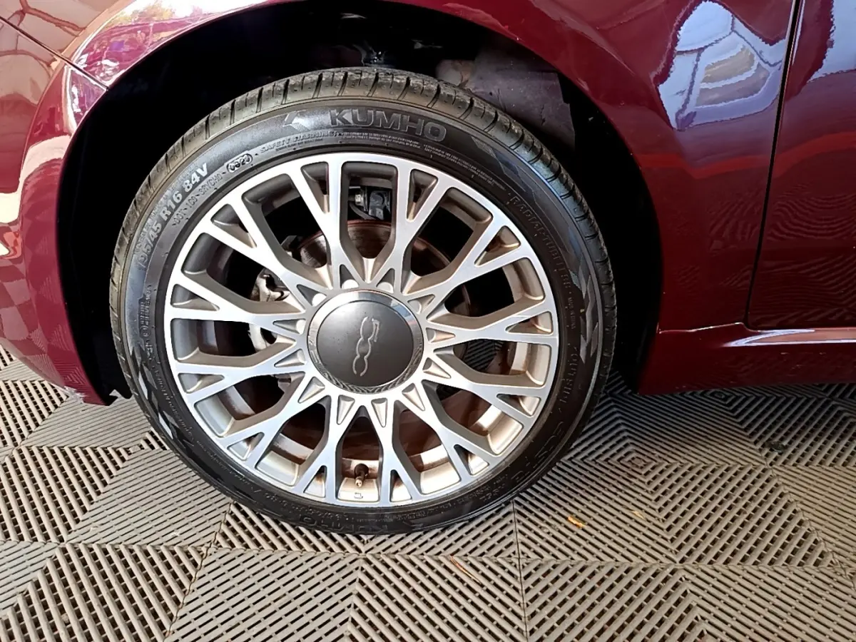 Gros plan sur la roue avant gauche d'une FIAT 500 rouge 2021 avec jante alliage multi-branches argentée