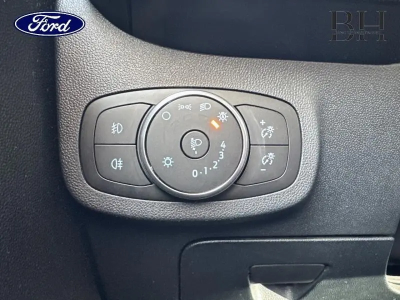 Gros plan sur le bouton de commande des phares et réglages d'éclairage intérieur du Ford Fiesta 2020, intérieur noir.