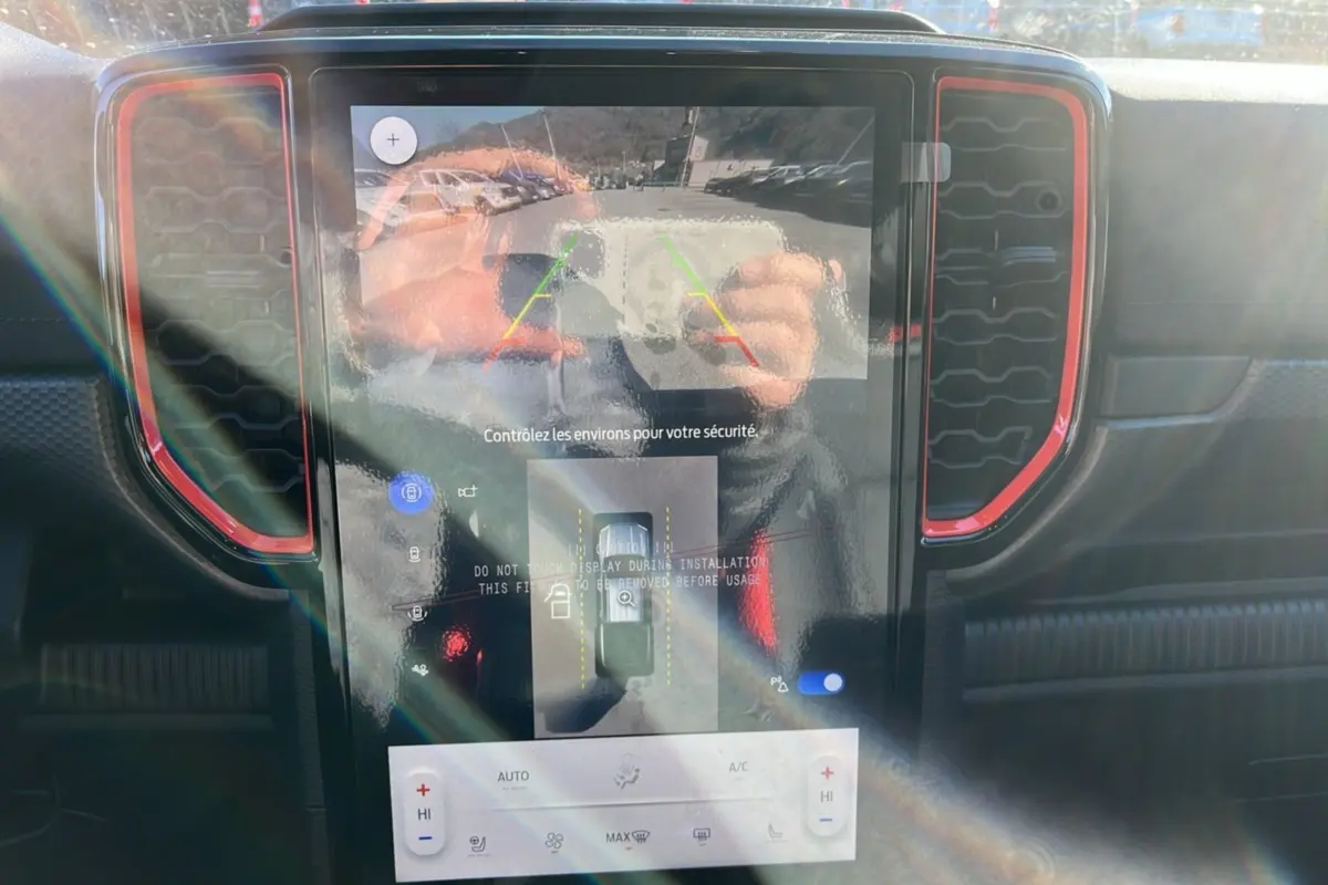 Écran central tactile du Ford Ranger Raptor 2025 avec caméra 360°, entouré de contours rouges sur tableau de bord noir.