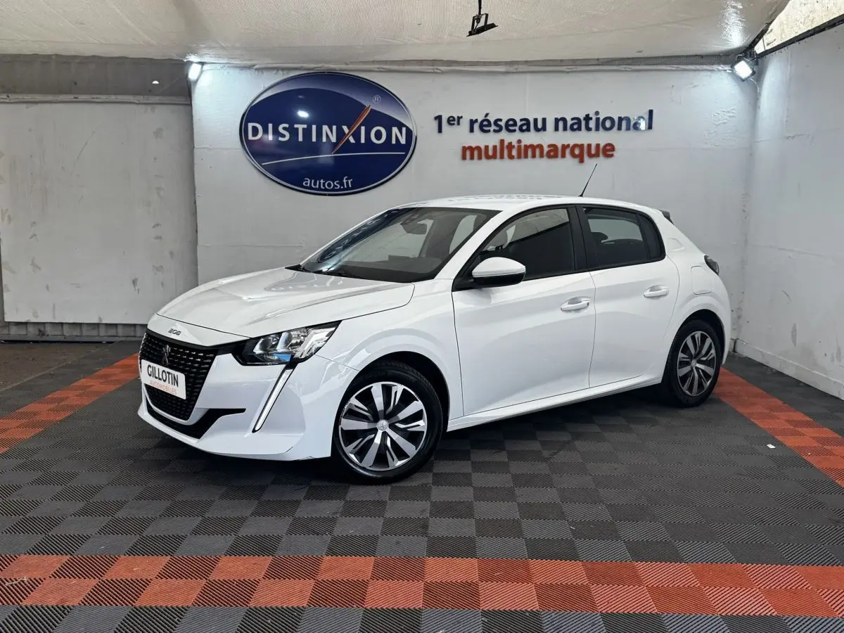 Peugeot 208 blanc vue 3/4 avant droit, avec calandre noire distinctive et jantes bicolores modernes.