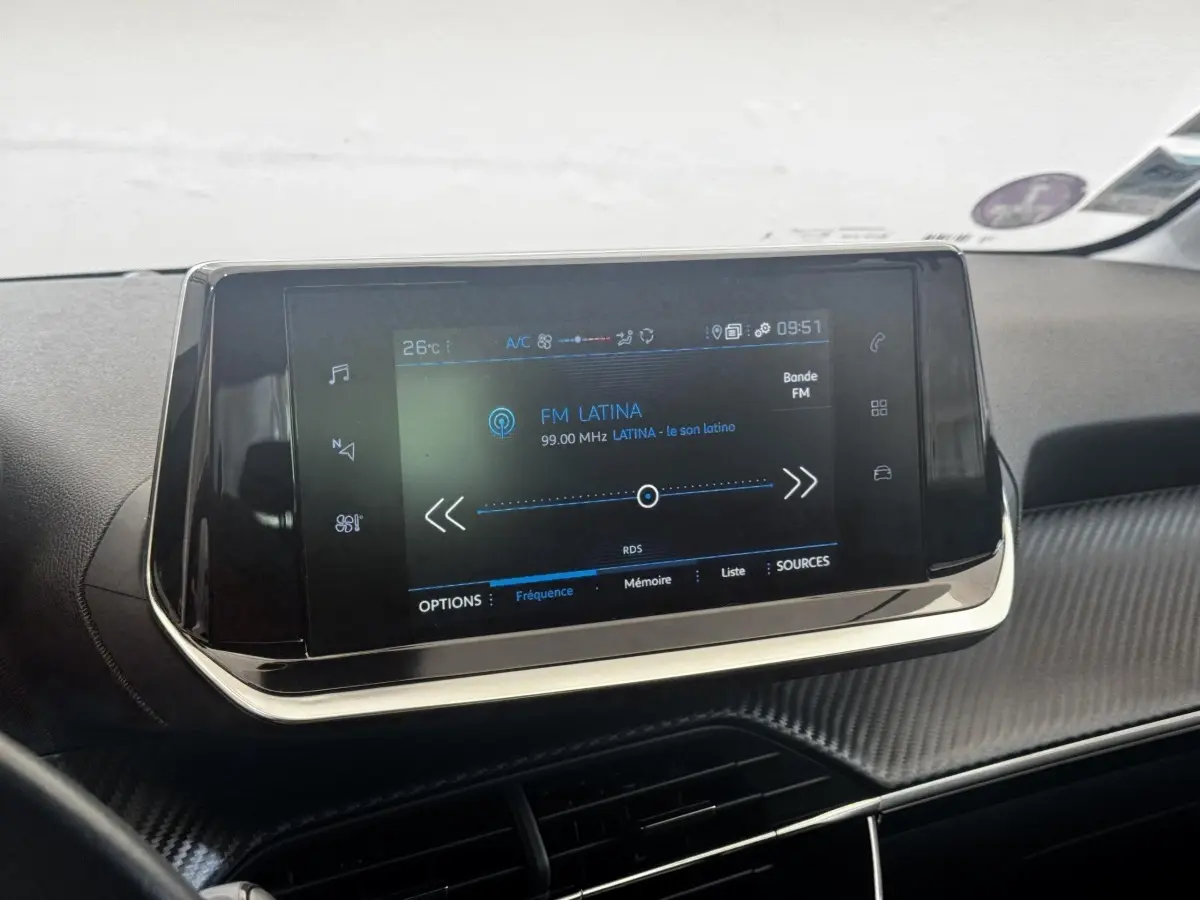 Écran tactile central affichant la radio FM dans l'habitacle noir du Peugeot 208 PureTech 100 S&S Active Business.