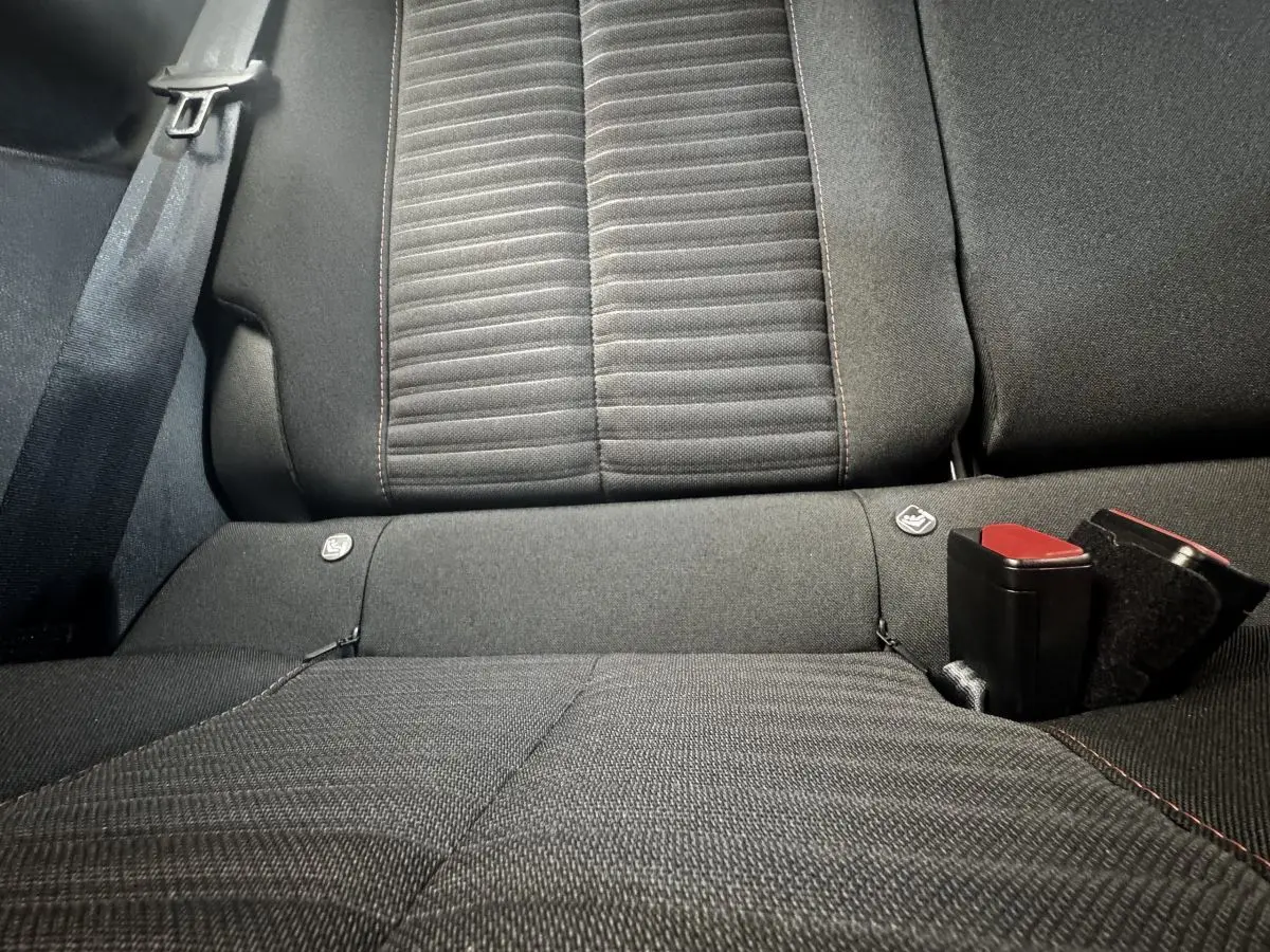 Vue rapprochée de la banquette arrière noire de la Peugeot 208 PureTech 100 S&S Active Business avec ceintures et fixations Isofix visibles.