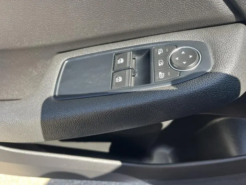 Gros plan sur les commandes de lève-vitres et rétroviseurs côté conducteur de la Renault Clio 1.6 E-Tech noir étoile de 2020.