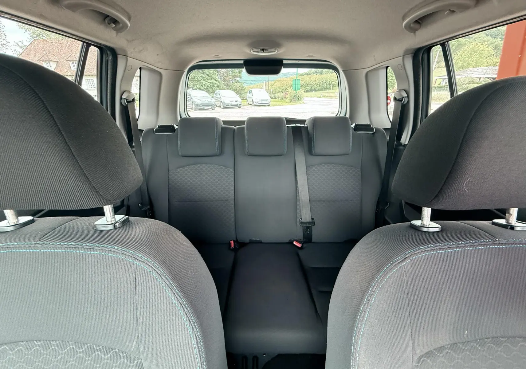 Vue intérieure arrière de la Mazda2 2004 montrant les sièges arrière et appuie-têtes en tissu noir.