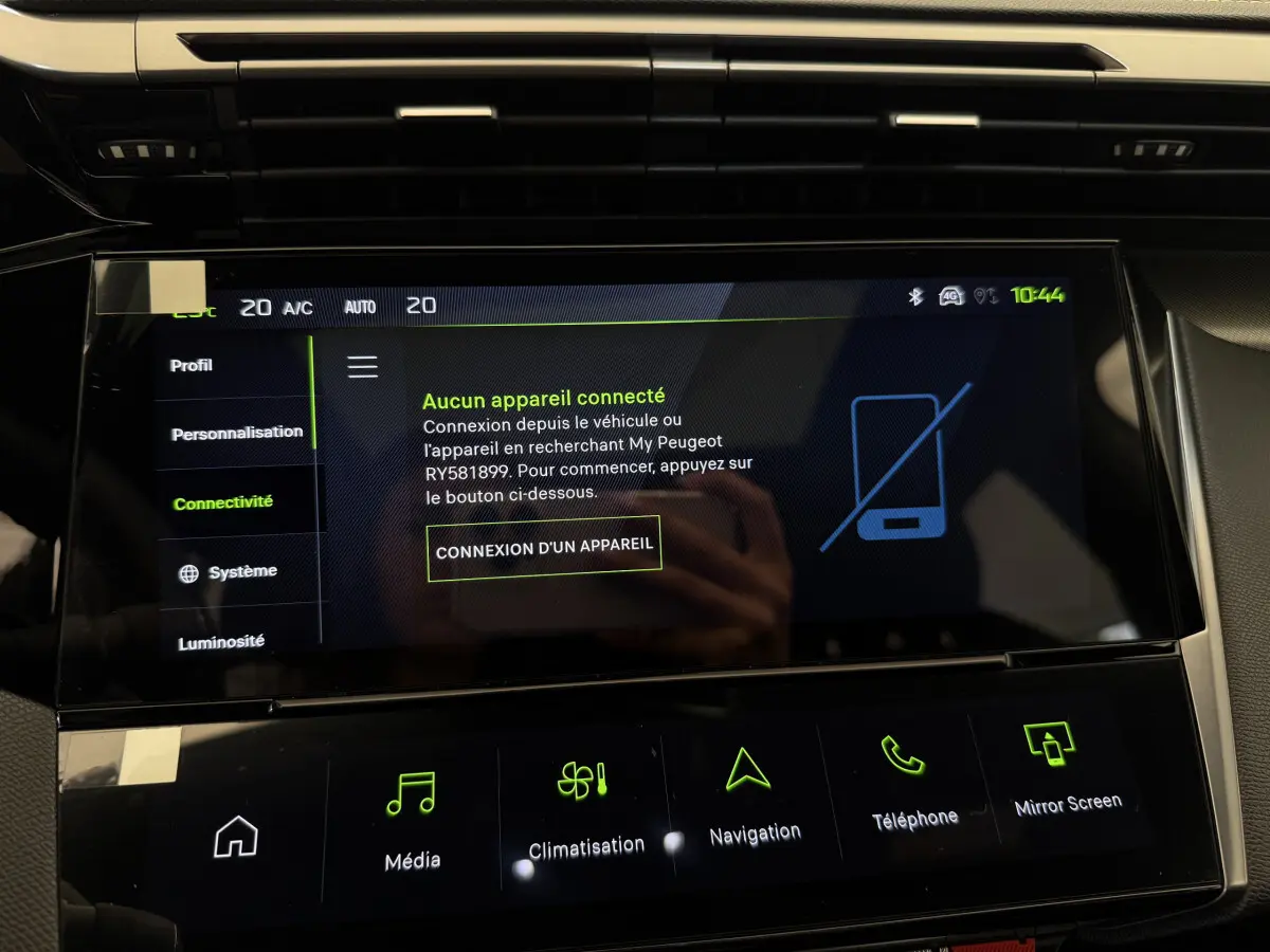 Gros plan sur l'écran tactile central noir affichant le menu connectivité dans l'habitacle d'une Peugeot 308 blanche.