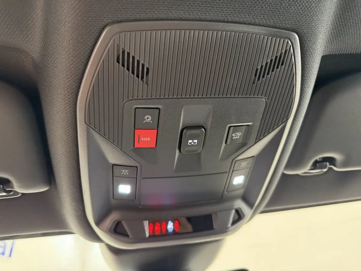 Vue en gros plan du panneau de commandes au plafond intérieur du Peugeot 308 Hybrid blanc, avec boutons SOS et éclairage.