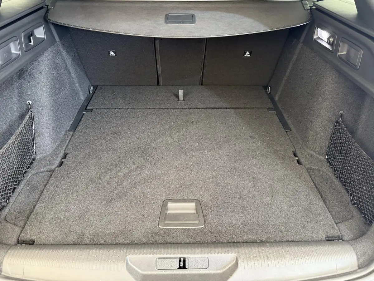 Vue intérieure du coffre spacieux et tapissé en gris foncé du Peugeot 308 Hybrid 136 e-DCS6 GT blanc 2024.