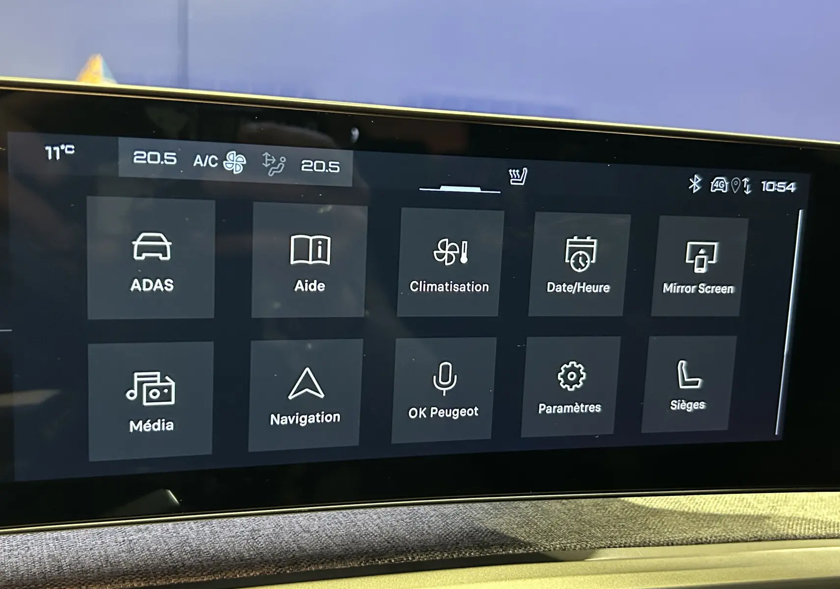 Écran tactile central du Peugeot 5008 Hybrid 2025 affichant les options de climatisation, navigation et aides à la conduite.