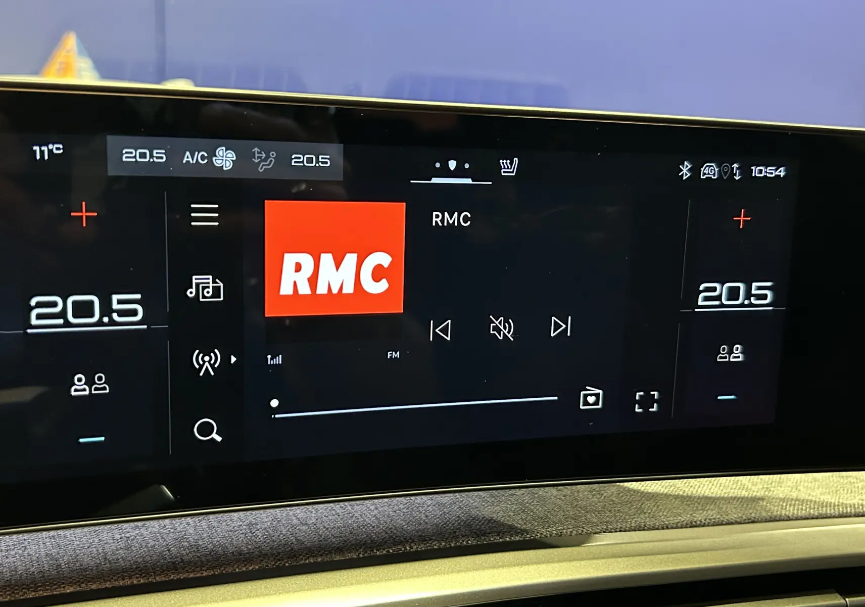 Écran tactile central du Peugeot 5008 Hybrid 2025 affichant la radio RMC et la climatisation à 20,5°C.