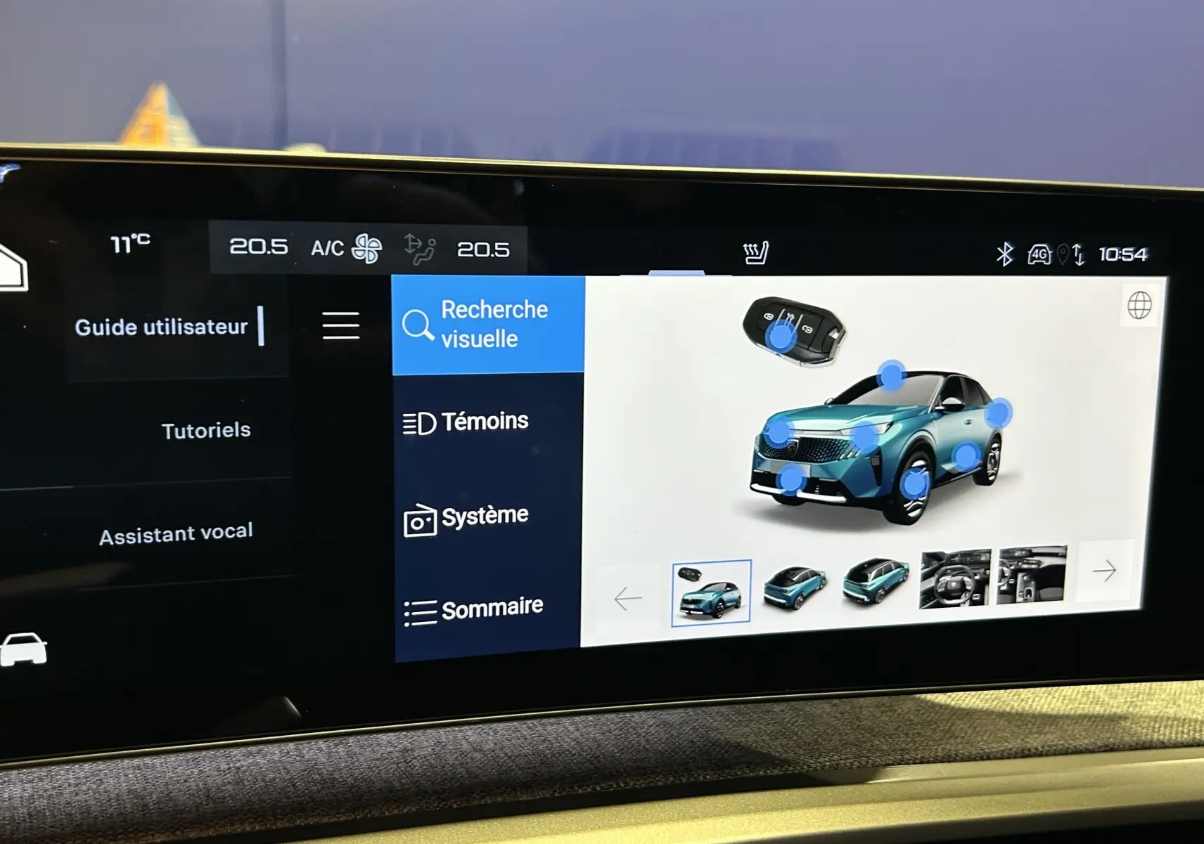 Vue 3/4 avant droite du Peugeot 5008 III Hybrid 145 GT en bleu Obsession sur l'écran tactile du tableau de bord.