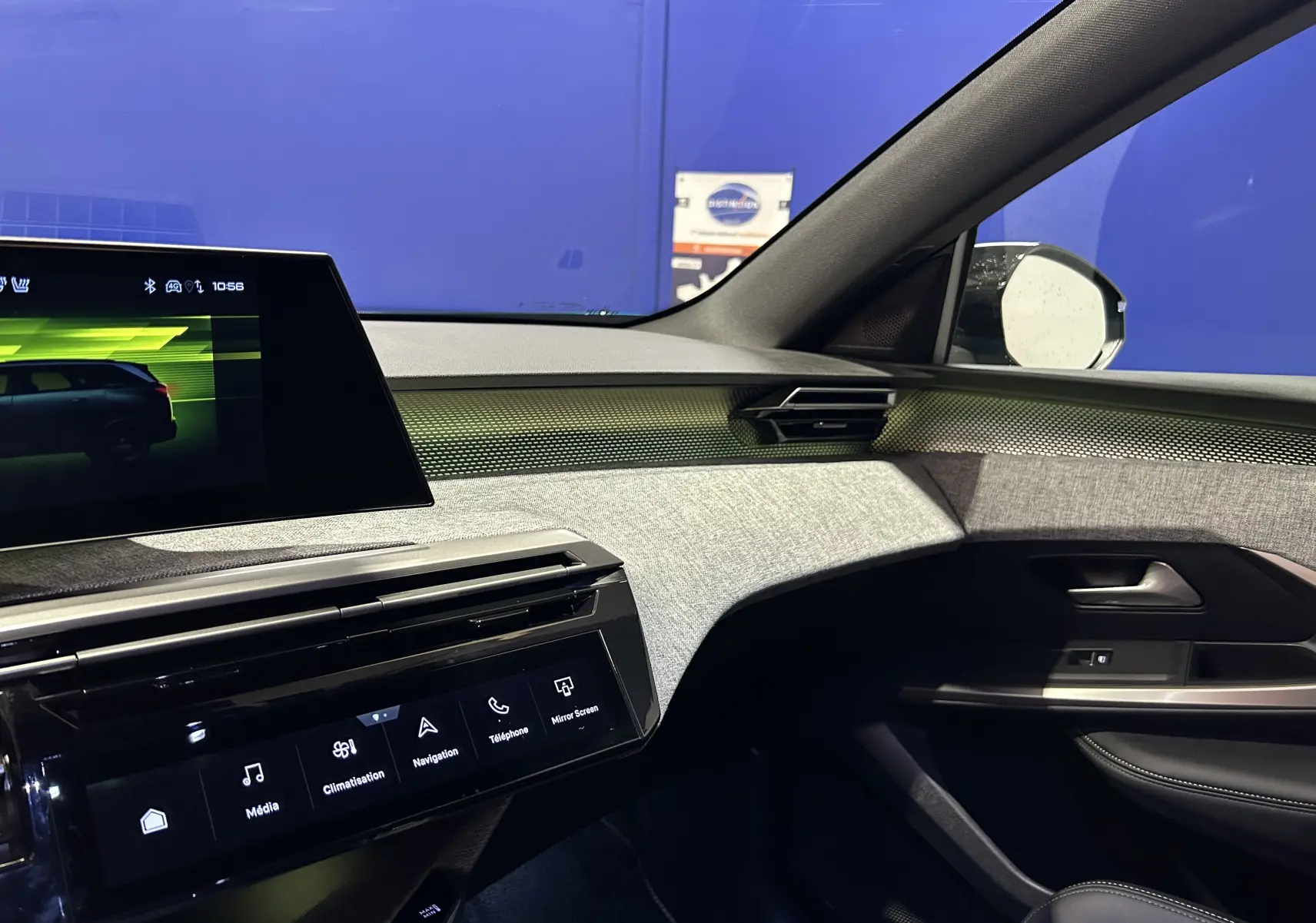 Intérieur côté passager du Peugeot 5008 Hybrid 2025, tableau de bord moderne avec écran tactile et finitions tissu gris.