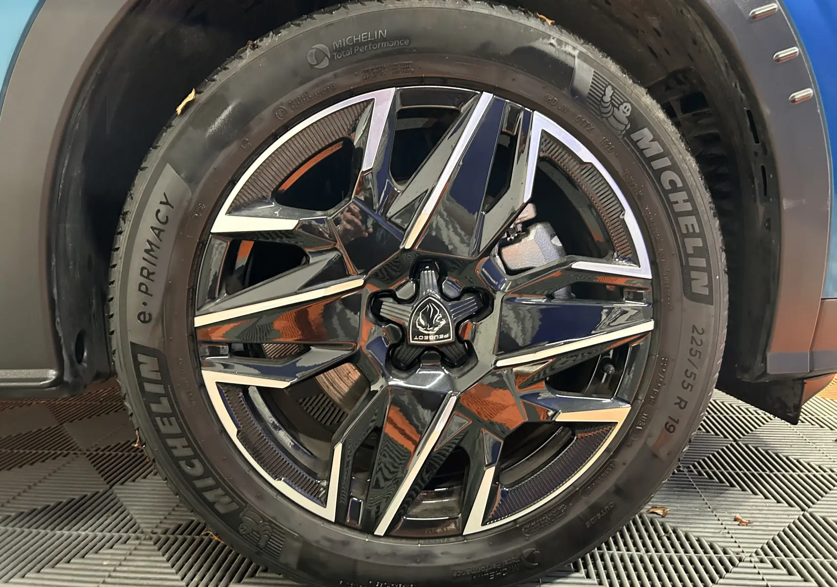 Gros plan sur la jante noire et argentée du PEUGEOT 5008 III HYBRID 145 e-DSC6 GT bleu Obsession avec pneu Michelin.