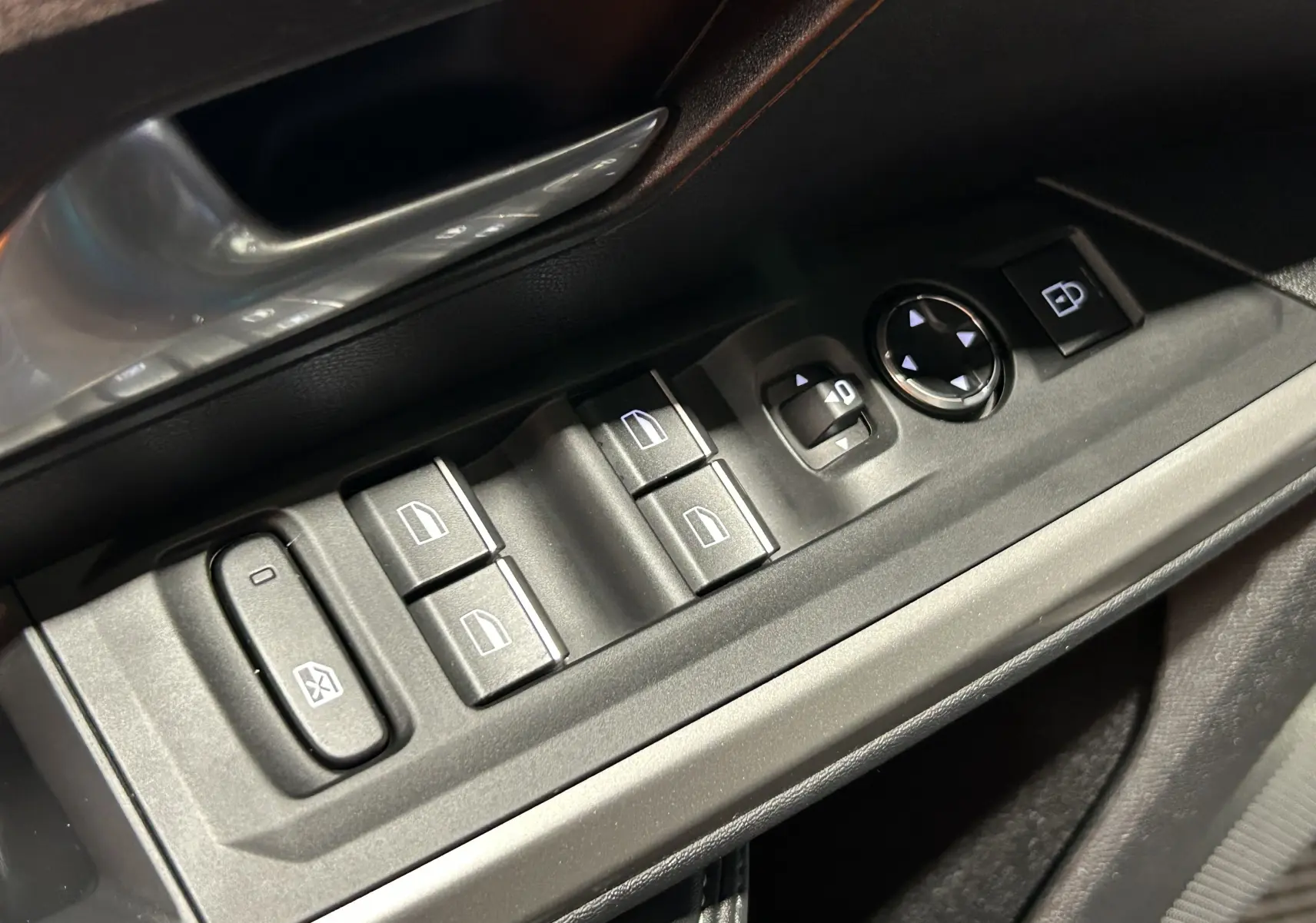 Gros plan sur les commandes électriques côté conducteur du PEUGEOT 5008 III HYBRID 145 e-DSC6 GT, finition noire.