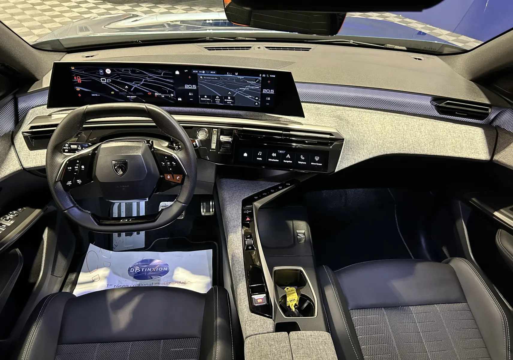 Vue intérieure avant du Peugeot 5008 III Hybrid 145 GT avec tableau de bord numérique et sellerie cuir noire.