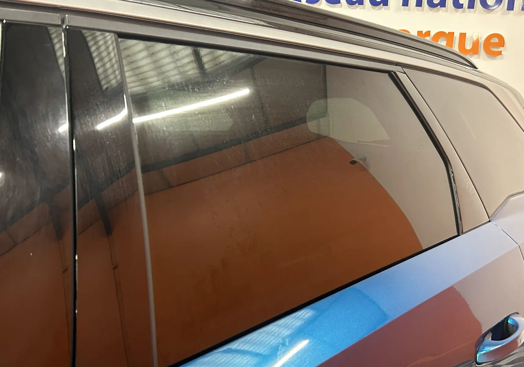 Vue latérale côté droit sur la porte arrière bleu obsession du Peugeot 5008 III Hybrid 145 e-DSC6 GT avec vitre teintée.