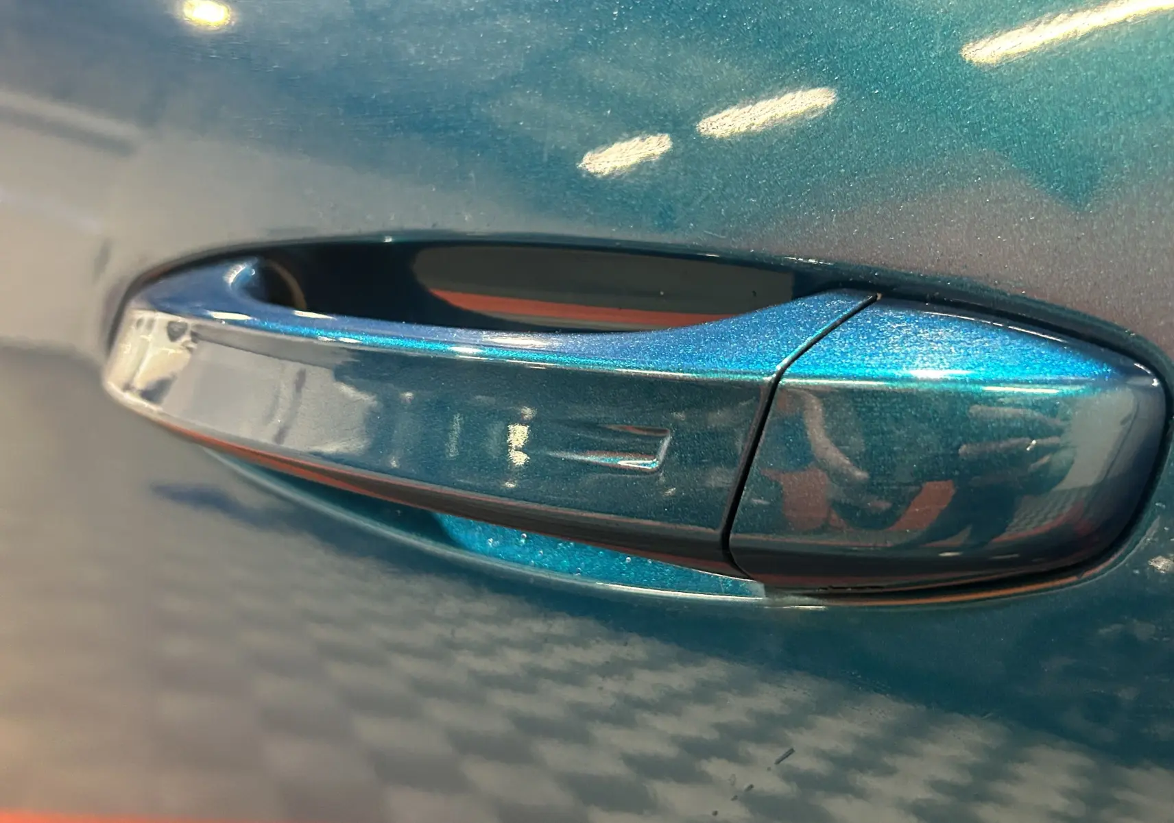 Poignée de porte bleu obsession en gros plan sur Peugeot 5008 III Hybrid 145 e-DSC6 GT 2025