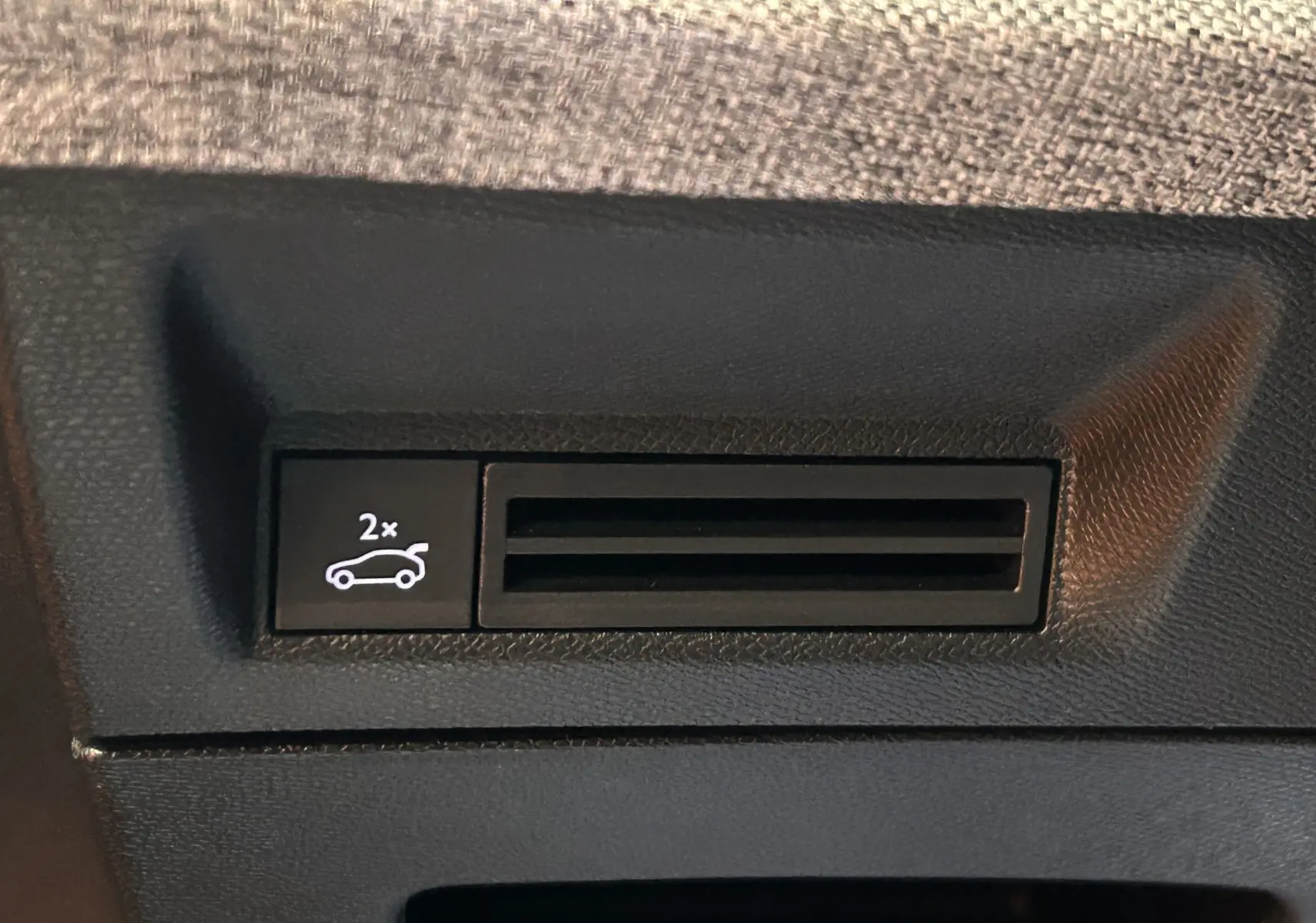 Bouton d'ouverture du hayon électrique sur le panneau intérieur d'une Peugeot 5008 hybride bleu obsession.