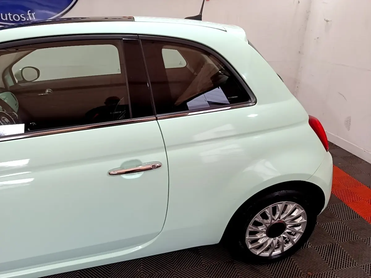 Profil arrière droit d'une Fiat 500 Lounge verte pastel avec jantes alliage et poignée chromée visible.