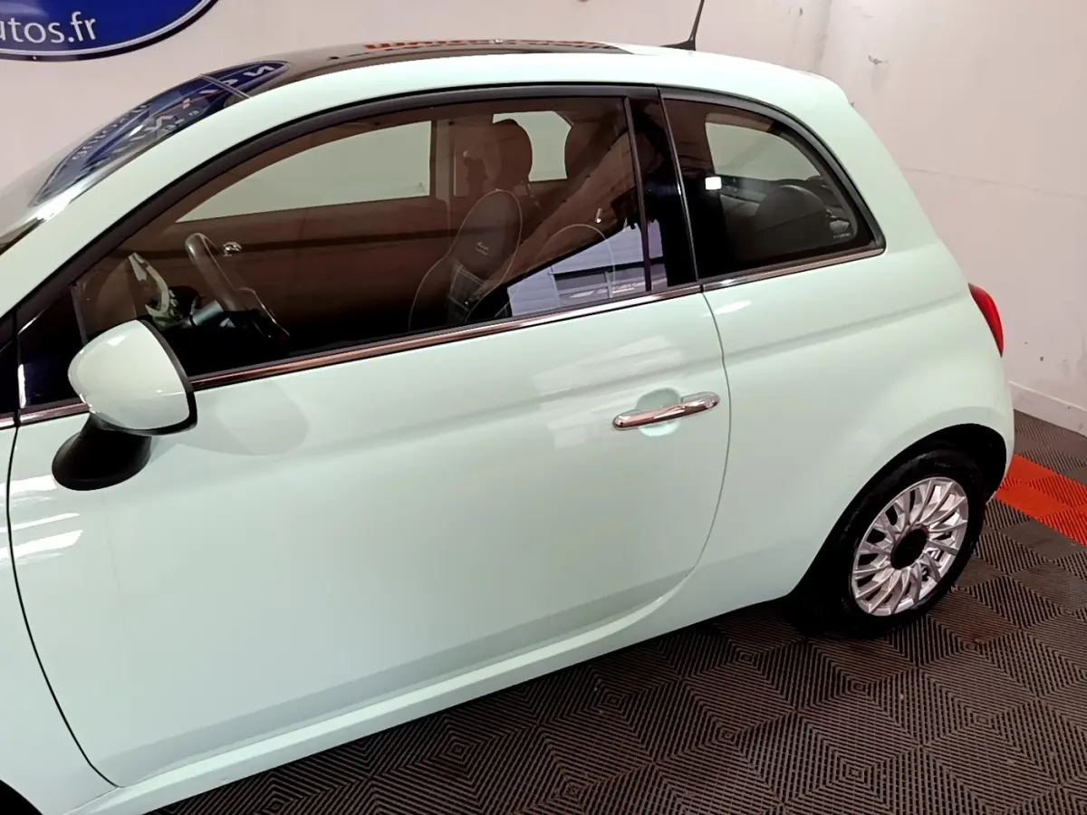 Profil côté gauche d'une FIAT 500 Lounge 2019 vert clair, mettant en valeur la portière et la jante en alliage.