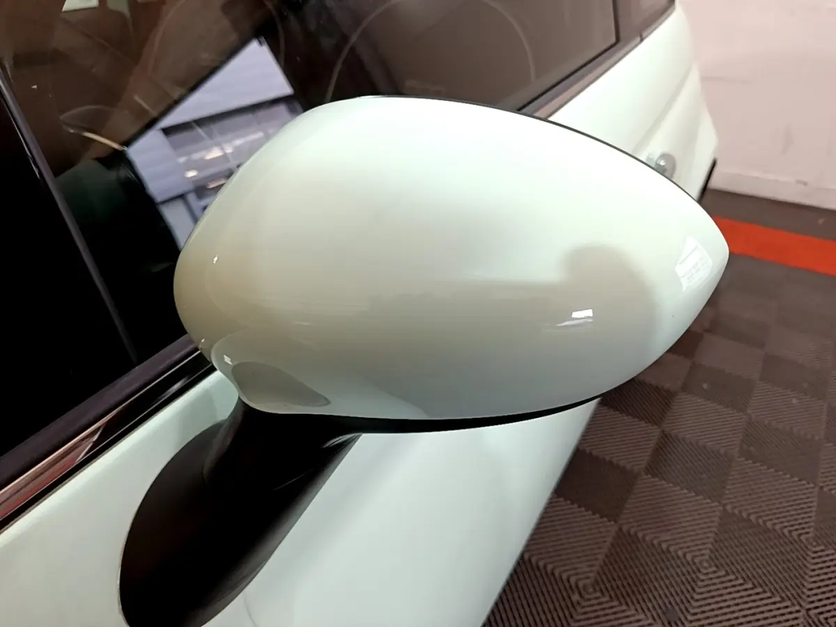 Gros plan sur le rétroviseur côté droit vert clair d'une FIAT 500 Lounge 2019, avec carrosserie et vitre partiellement visibles.