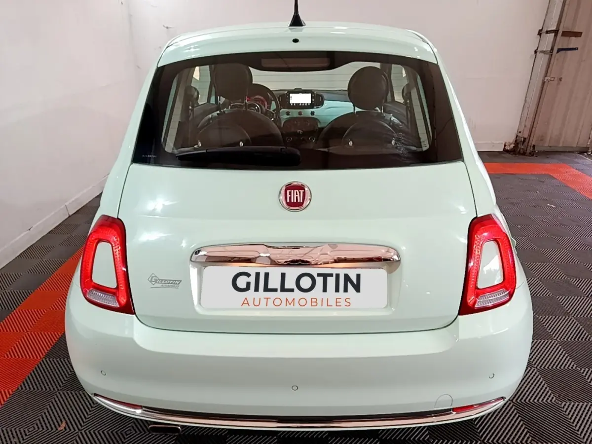 Vue arrière d'une FIAT 500 Lounge 2019 vert clair avec feux arrière rouges et logo Fiat visible.