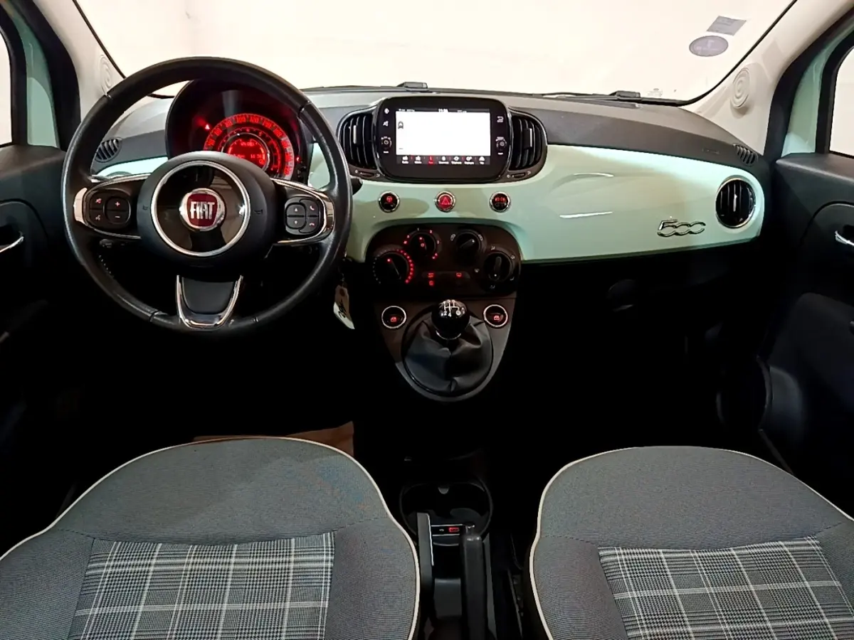 Vue intérieure avant de la FIAT 500 Lounge 2019 avec tableau de bord vert clair et volant cuir multifonctions.