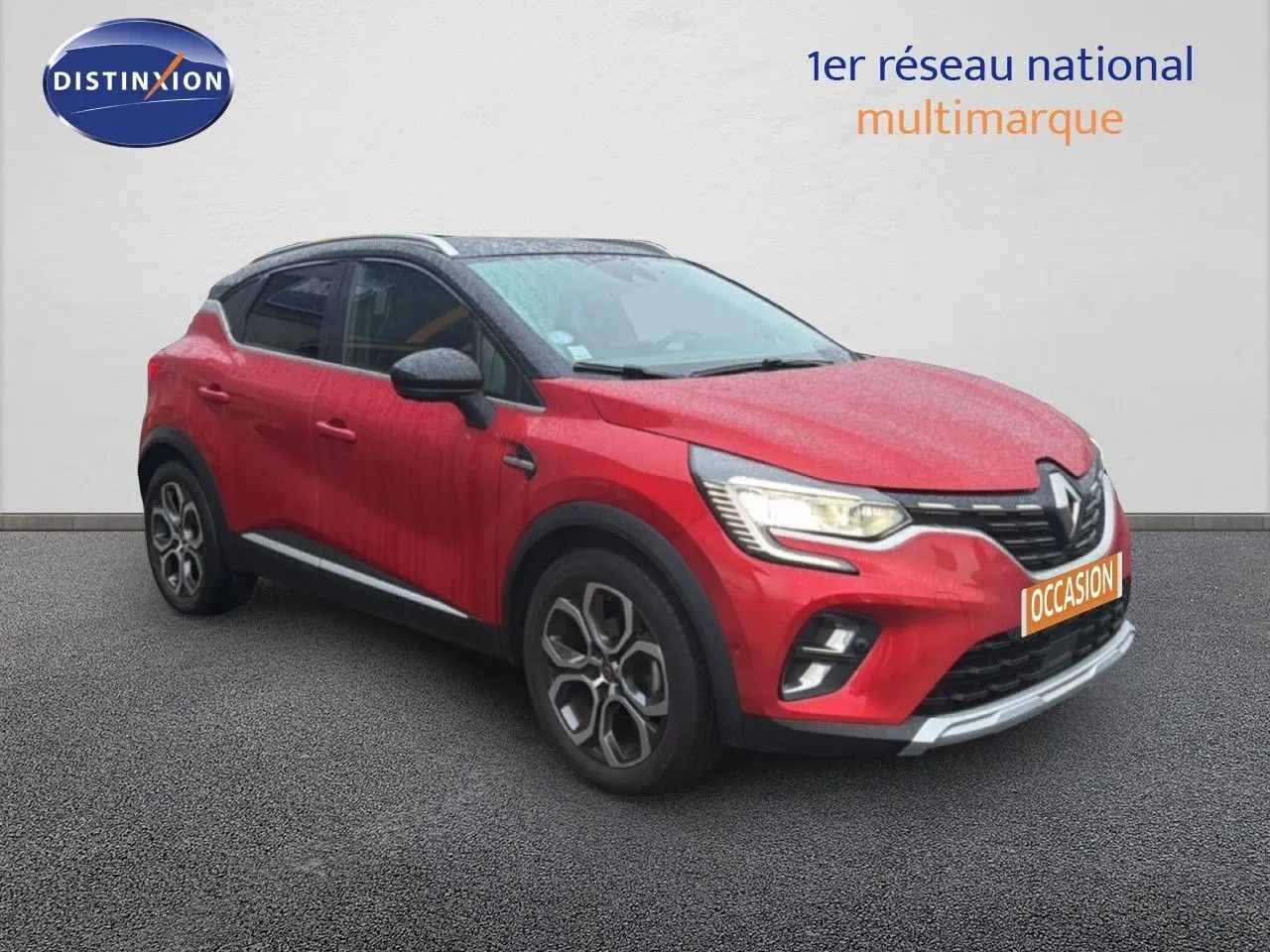 Renault Captur rouge flamme en 3/4 avant droit avec jantes bi-ton et toit noir contrasté.