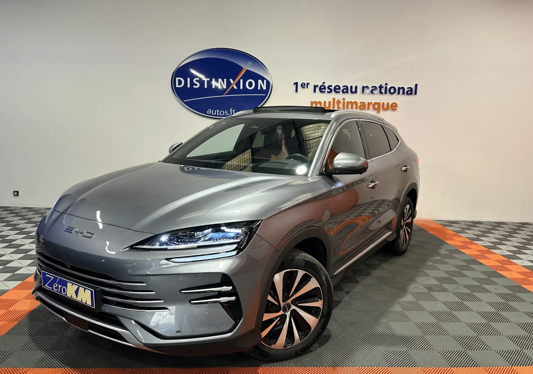 Vue 3/4 avant droite du SUV BYD SEAL U gris métallisé avec toit ouvrant et jantes bicolores en concession.