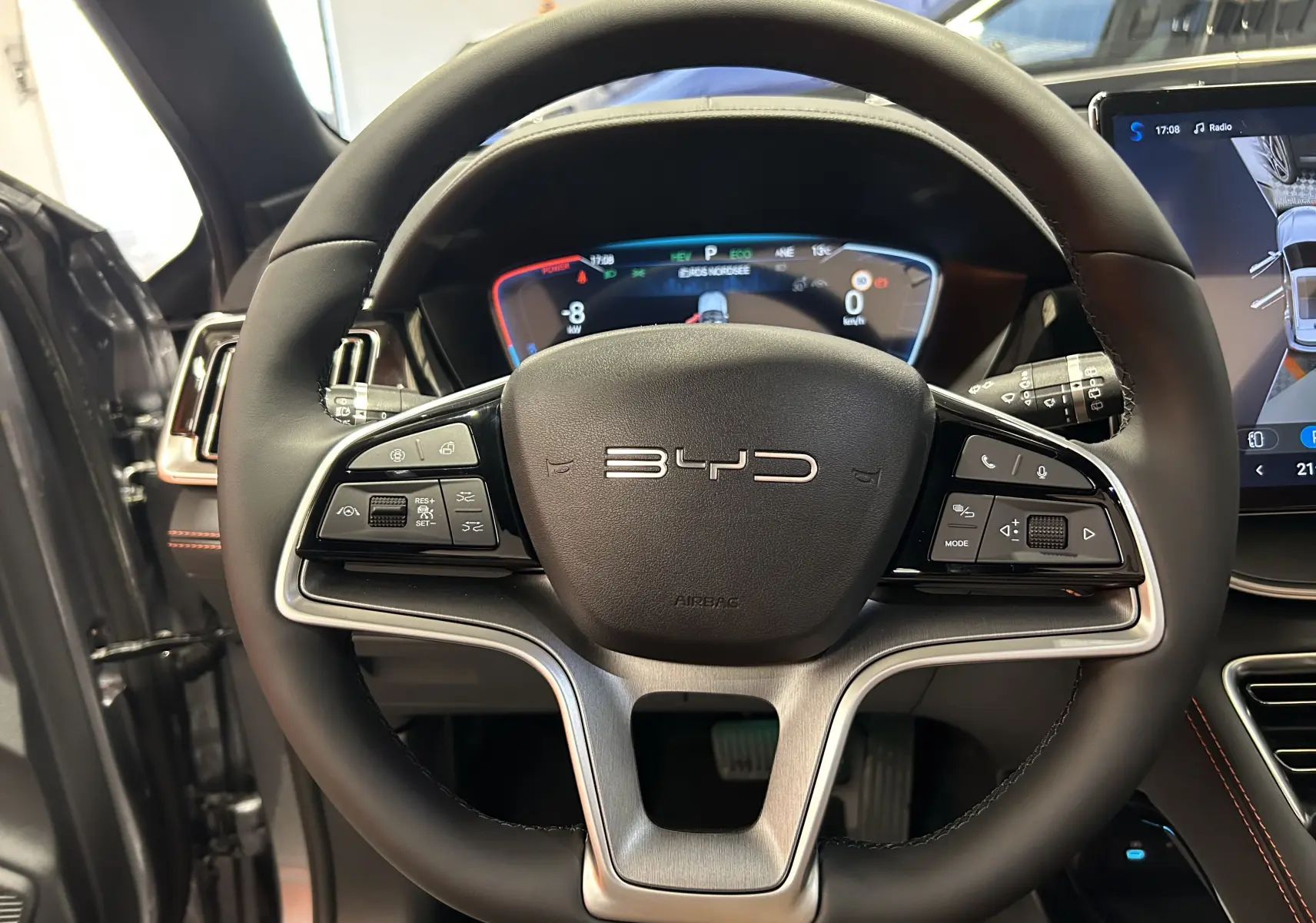 Vue rapprochée du volant noir du BYD SEAL U 2025 avec tableau de bord numérique et écran tactile latéral.