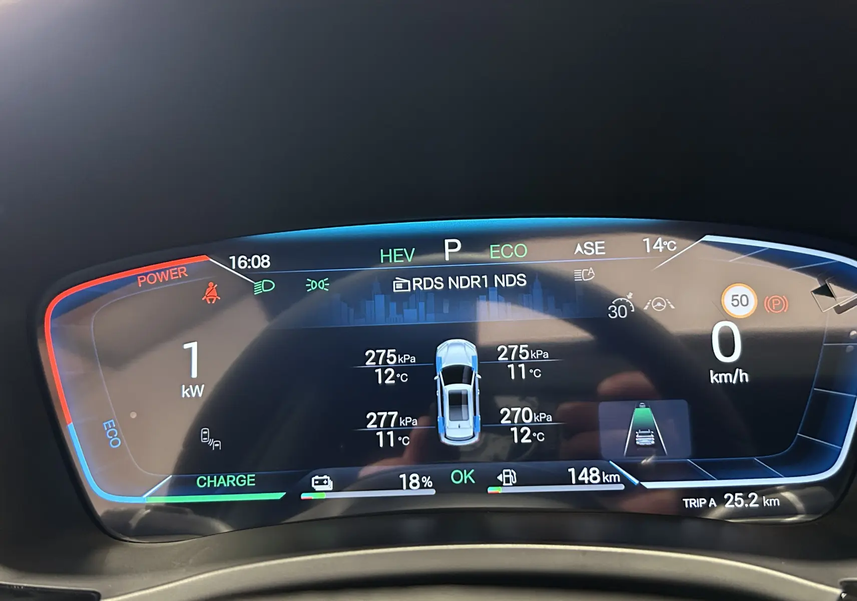 Tableau de bord numérique du BYD SEAL U affichant la pression des pneus et l'autonomie, vue de face en intérieur.