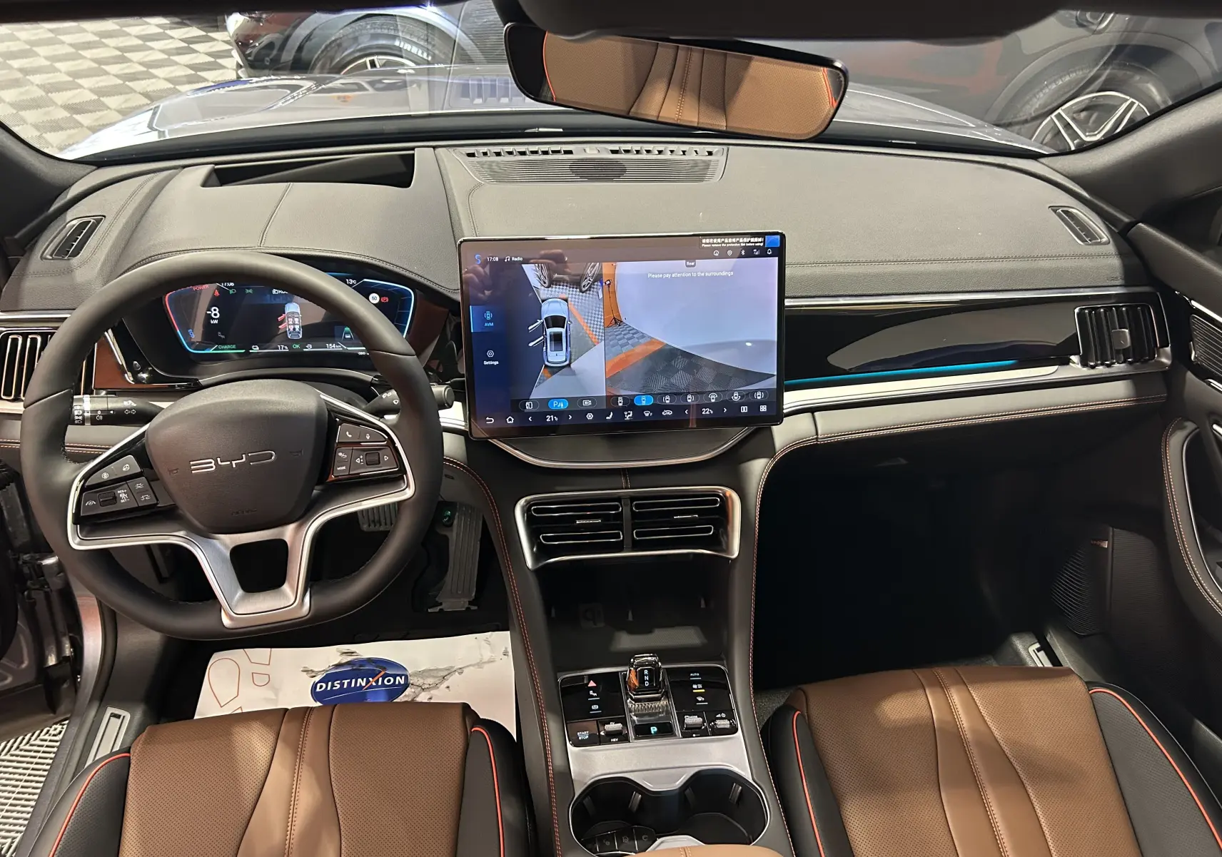 Vue intérieure avant du BYD SEAL U 2025 avec tableau de bord noir, écran tactile central et sièges en cuir marron.