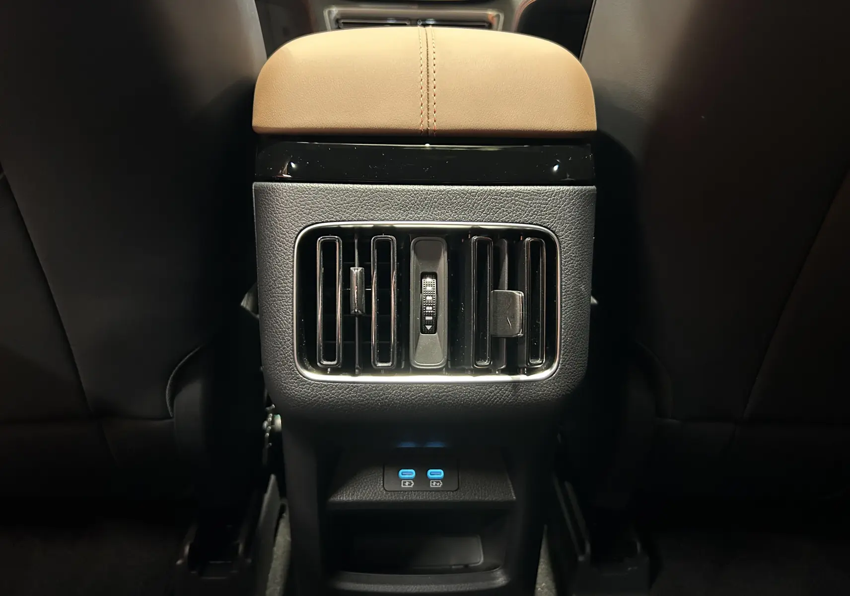 Vue rapprochée des aérateurs arrière et ports USB bleus sur console centrale, intérieur cuir marron du BYD SEAL U 2025.