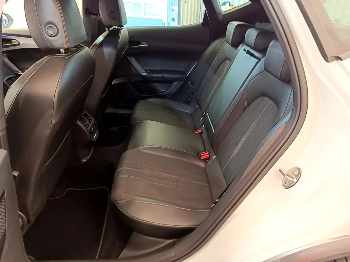 Vue intérieure côté droit des sièges arrière noirs en cuir et tissu du CUPRA Formentor 2023 avec surpiqûres rouges.