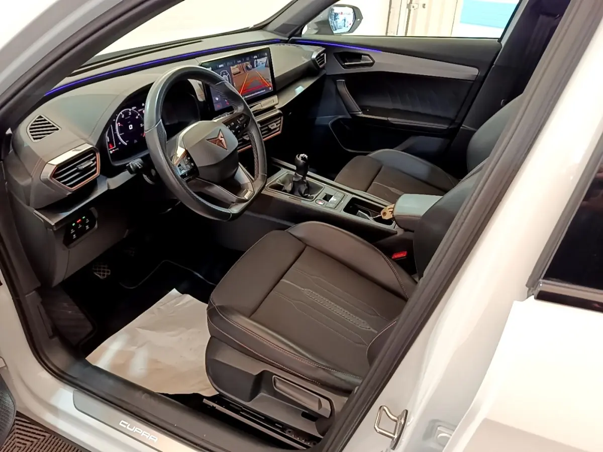 Intérieur avant droit du CUPRA Formentor blanc 2023, avec tableau de bord numérique et écran tactile central.