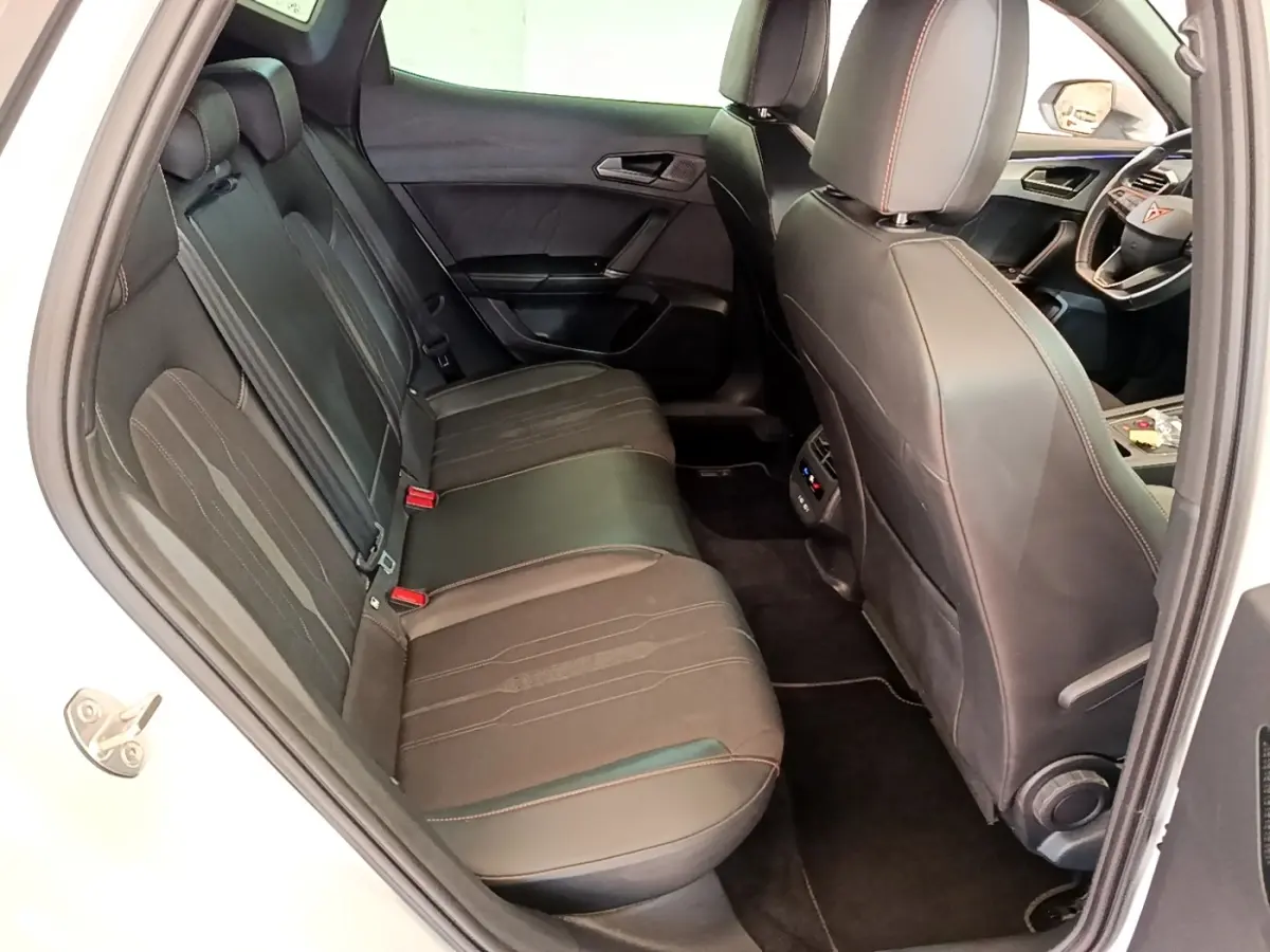 Vue intérieure côté gauche montrant la banquette arrière noire avec surpiqûres rouges du CUPRA Formentor 2023.