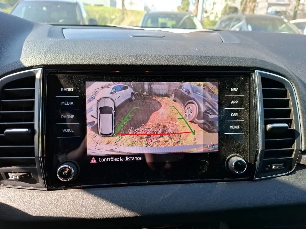 Écran multimédia du Skoda Karoq 2.0 TDI 116 DSG7 Business montrant la caméra de recul avec aide au stationnement.