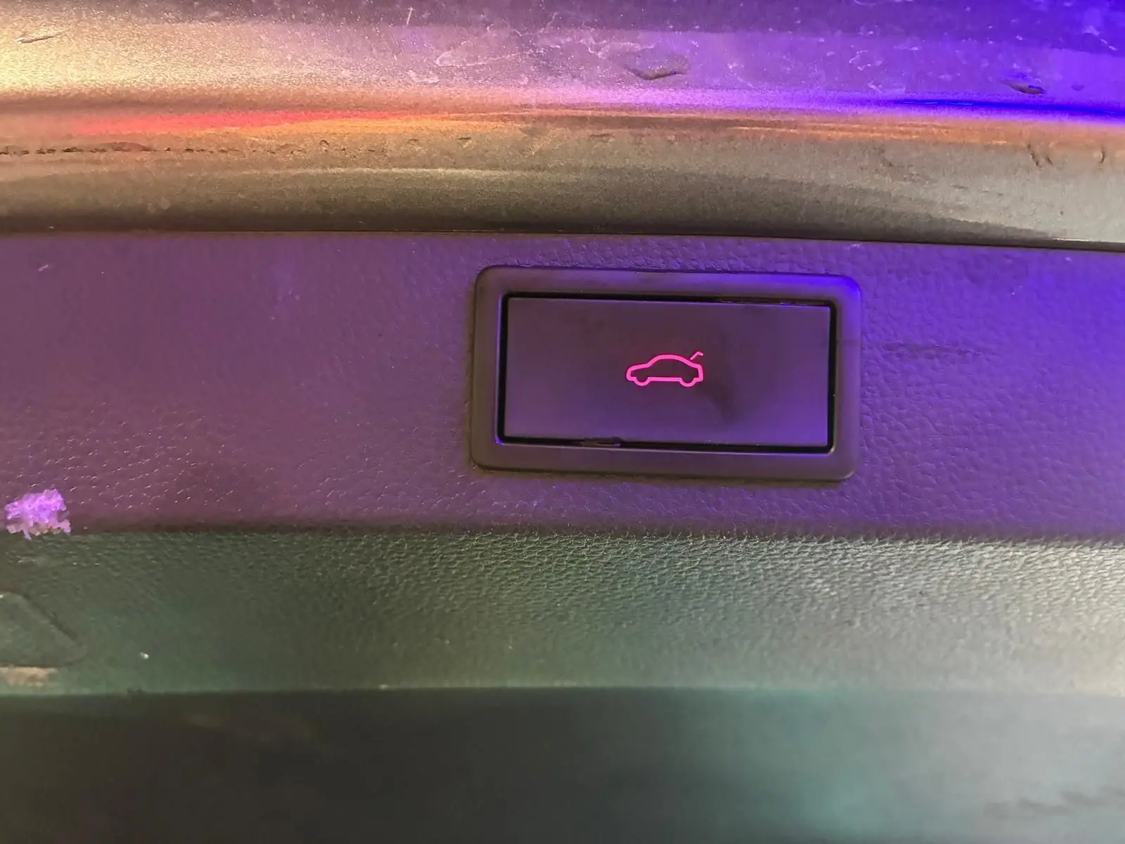 Bouton d'ouverture électrique du hayon sur le panneau intérieur d'un Skoda Karoq gris 2023.