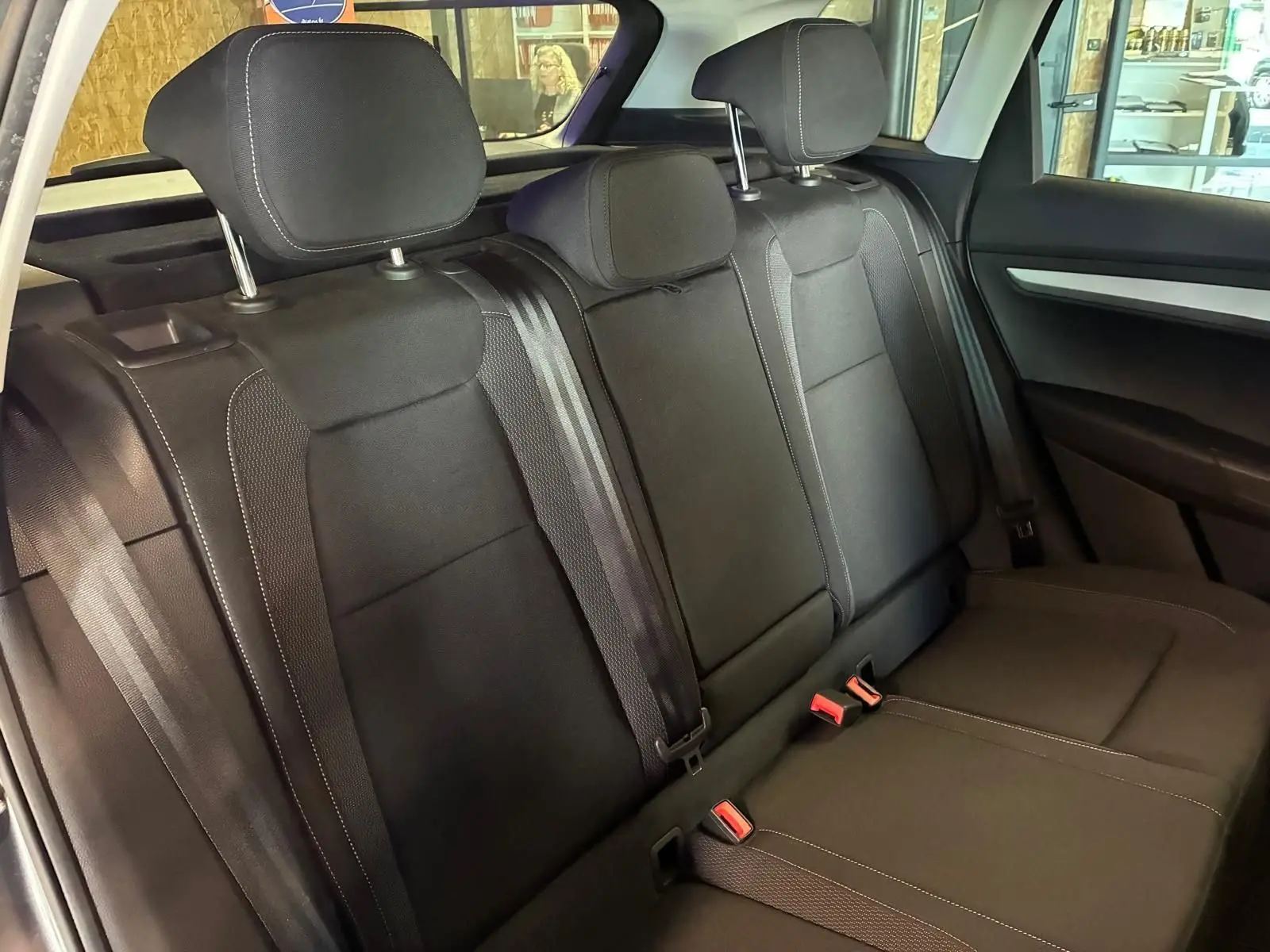 Vue intérieure des sièges arrière noirs de la Skoda Karoq 2023, avec appuie-têtes et ceintures de sécurité visibles.