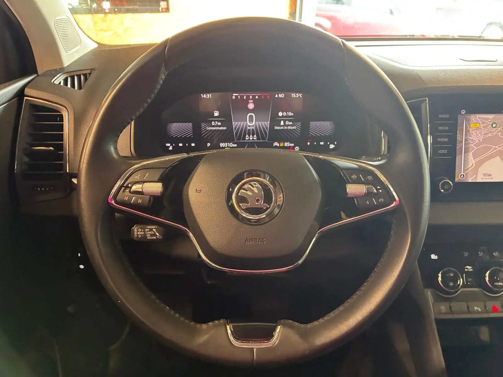Vue rapprochée du volant cuir multifonctions de la Skoda Karoq gris avec tableau de bord numérique et écran tactile.
