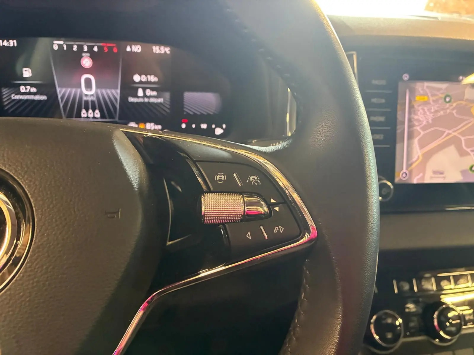 Gros plan sur le volant multifonctions cuir du Skoda Karoq 2.0 TDI 116 DSG7 Business avec tableau de bord numérique et écran tactile.