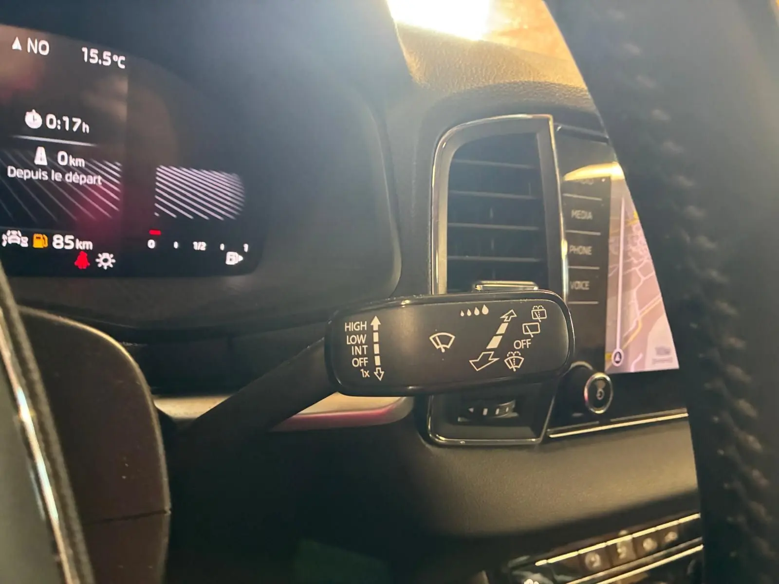 Gros plan sur la commande des essuie-glaces à gauche du volant dans l’habitacle gris du Skoda Karoq 2023.