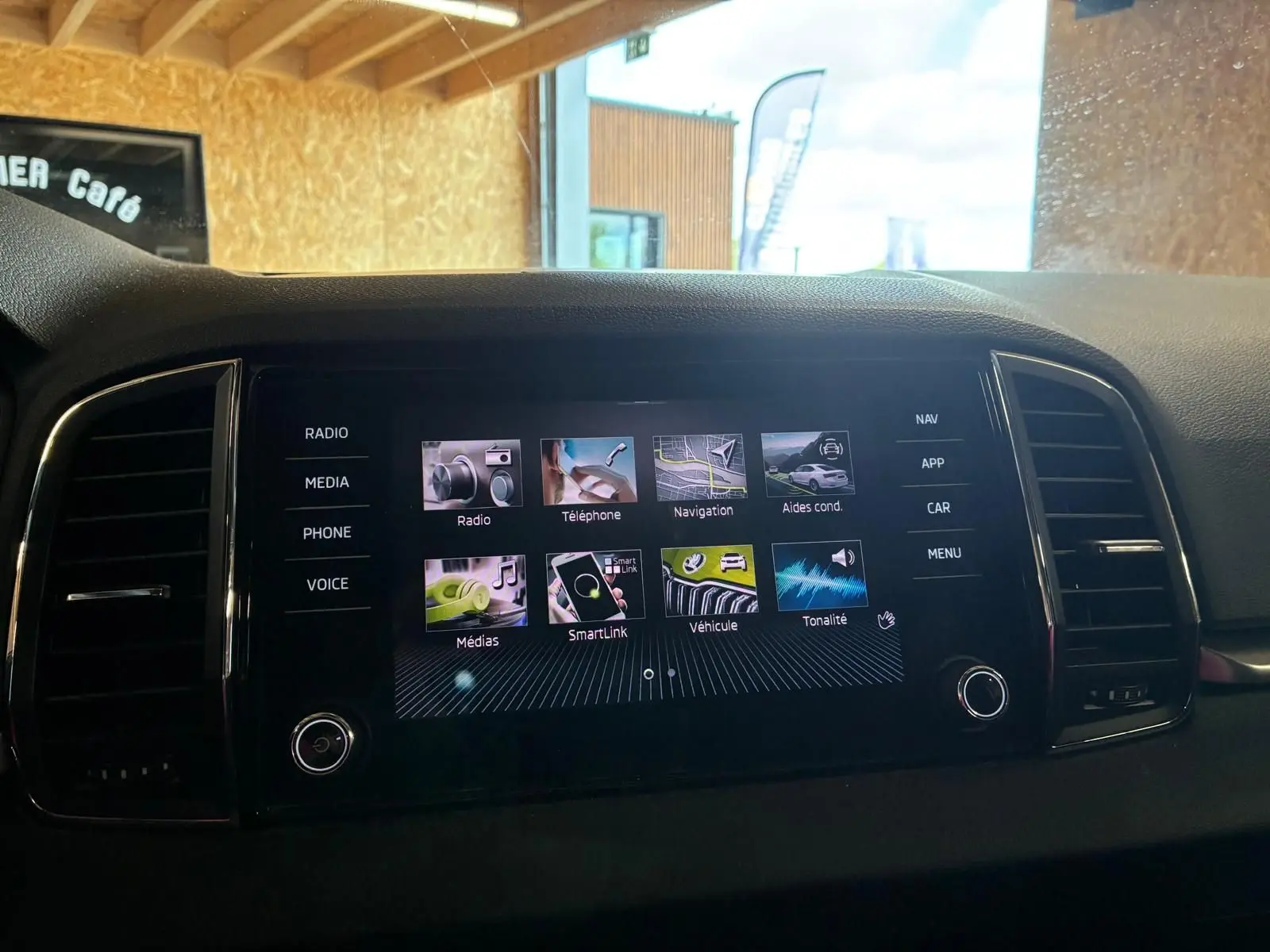 Écran tactile multimédia central du Skoda Karoq 2023 avec menus navigation, téléphone et SmartLink visibles.